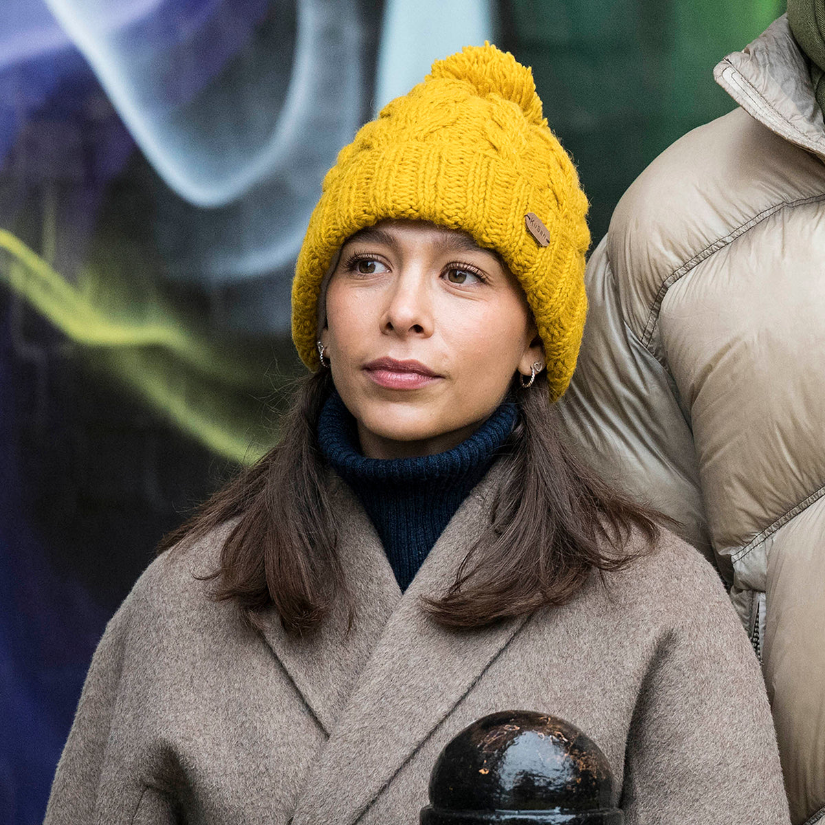 Gorro con pompón con vuelta de punto trenzado de Kusan - Mostaza